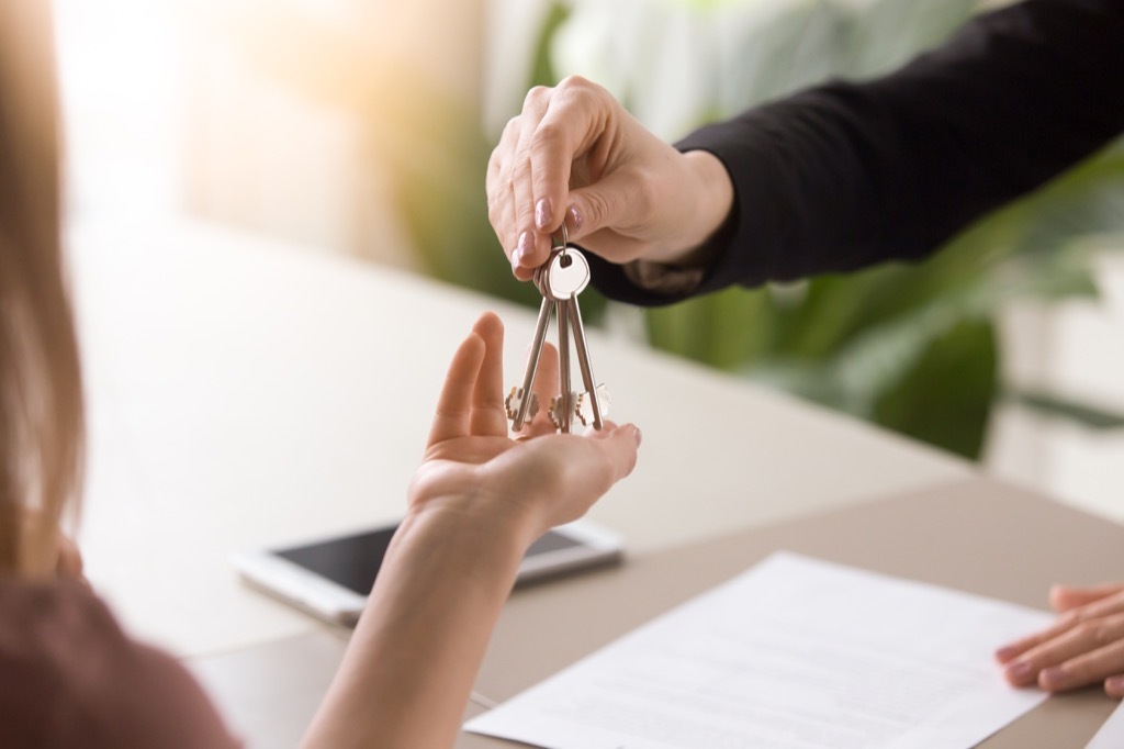 woman handing keys to another woman, downsizing your home