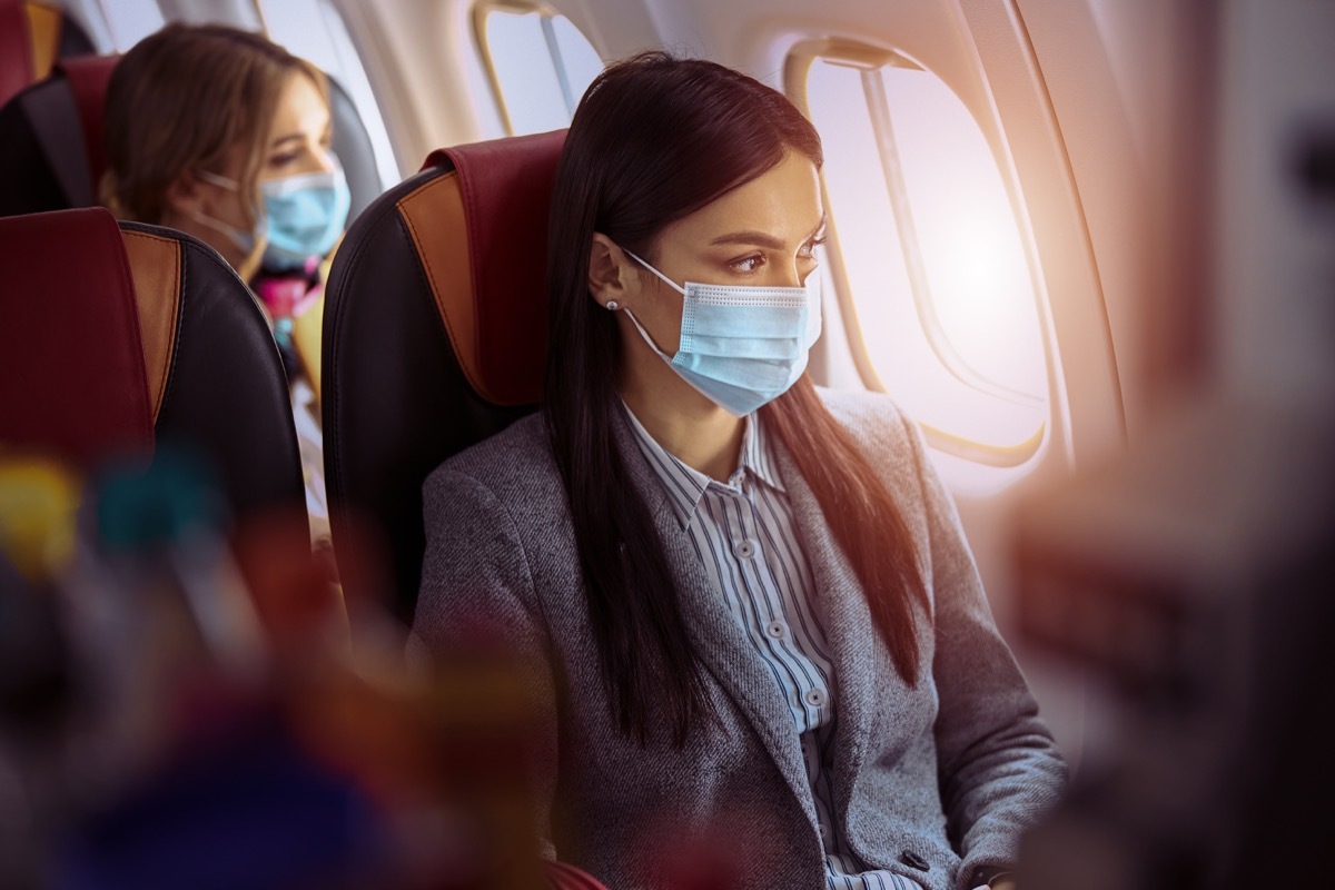 Woman is sitting in mask before flying on plane