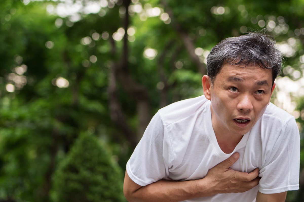 Man holding his chest having a hard time breathing