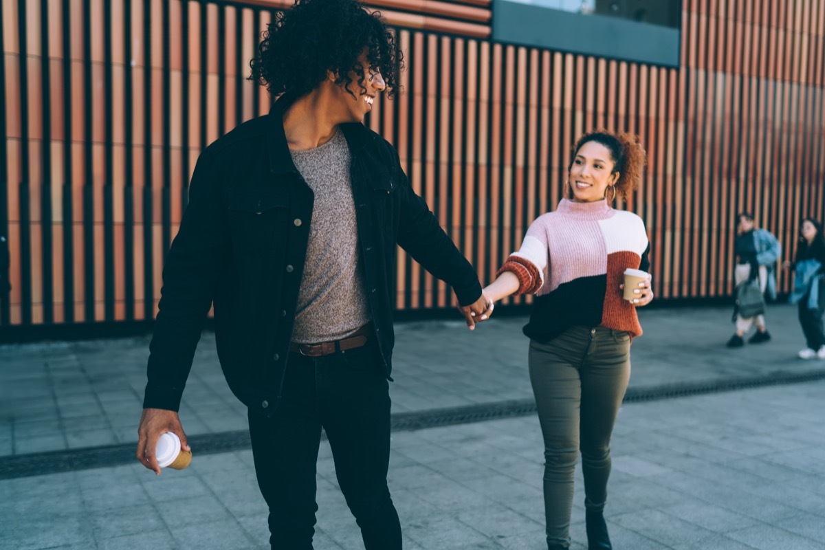 Confident boyfriend leading happy girlfriend