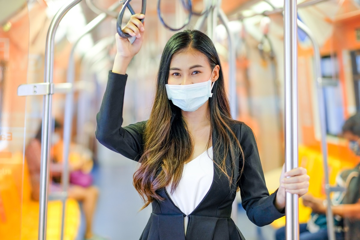 Woman holding subway pole