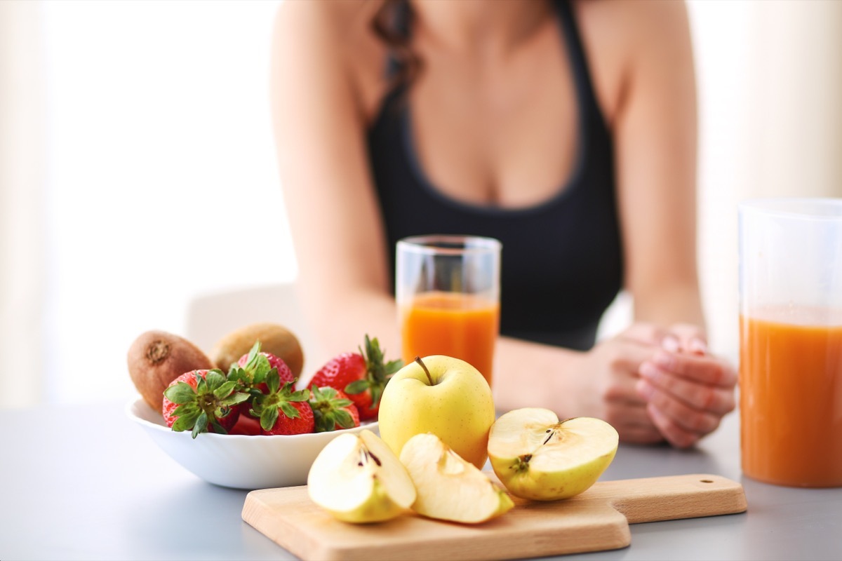 Woman eating a bowl full of fruits.