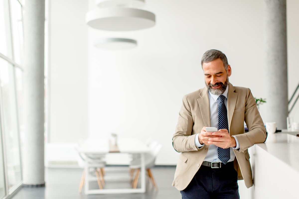 older man sending an email on phone, etiquette mistakes