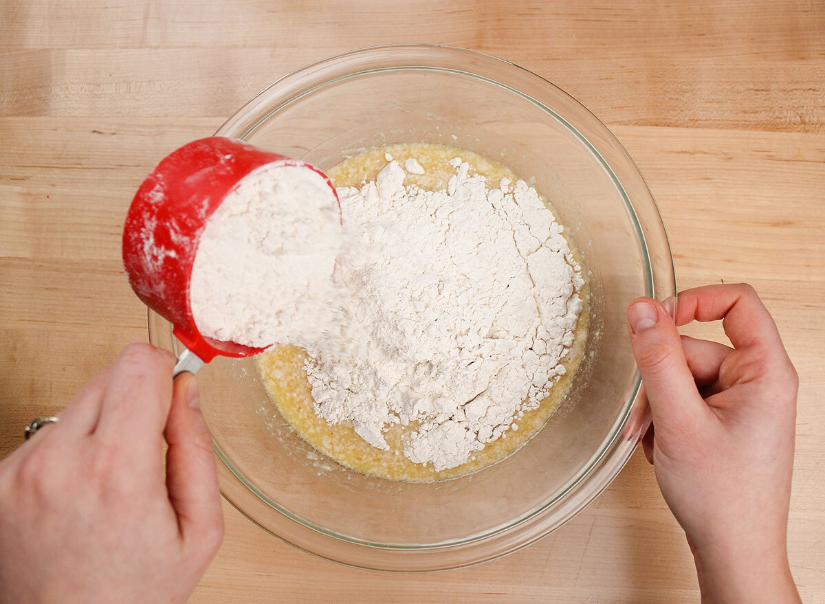 sprinkling flour and salt into wet yeast mixture for donuts