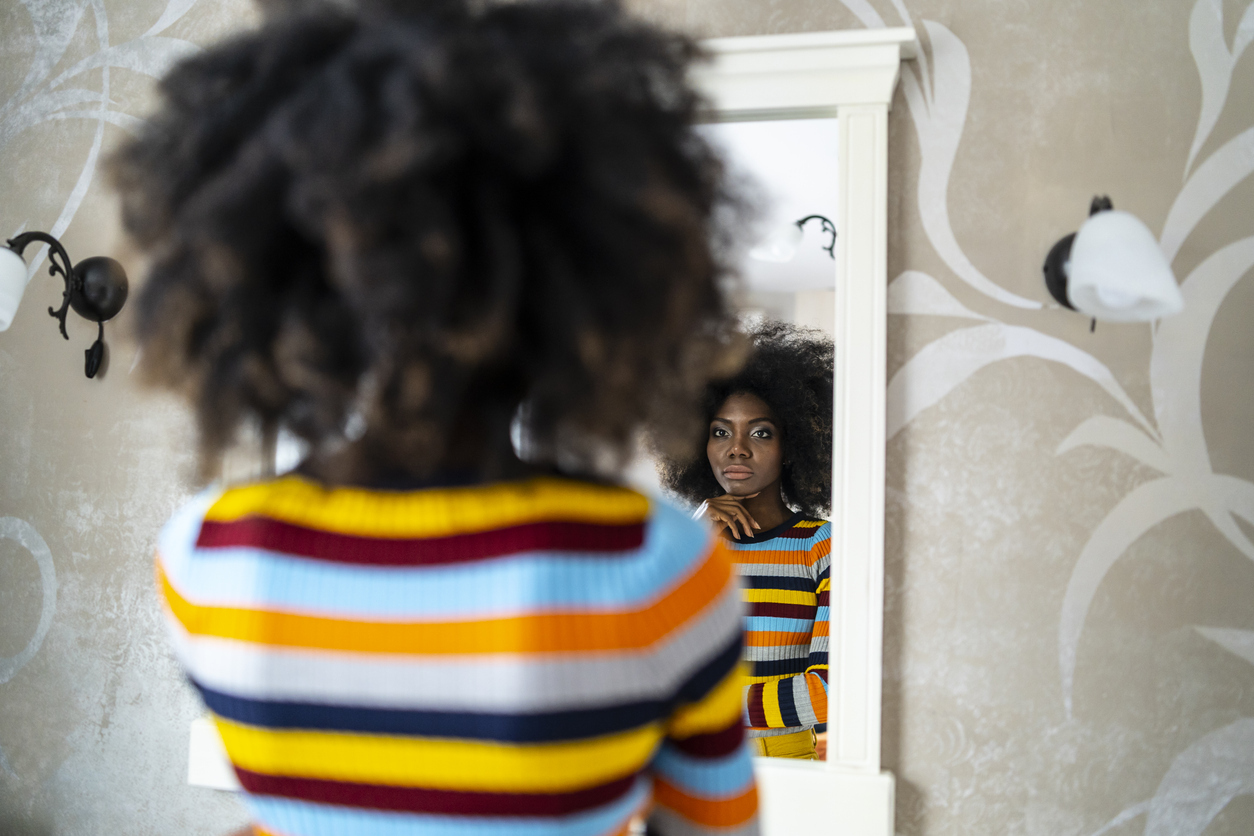 black woman looking in mirror