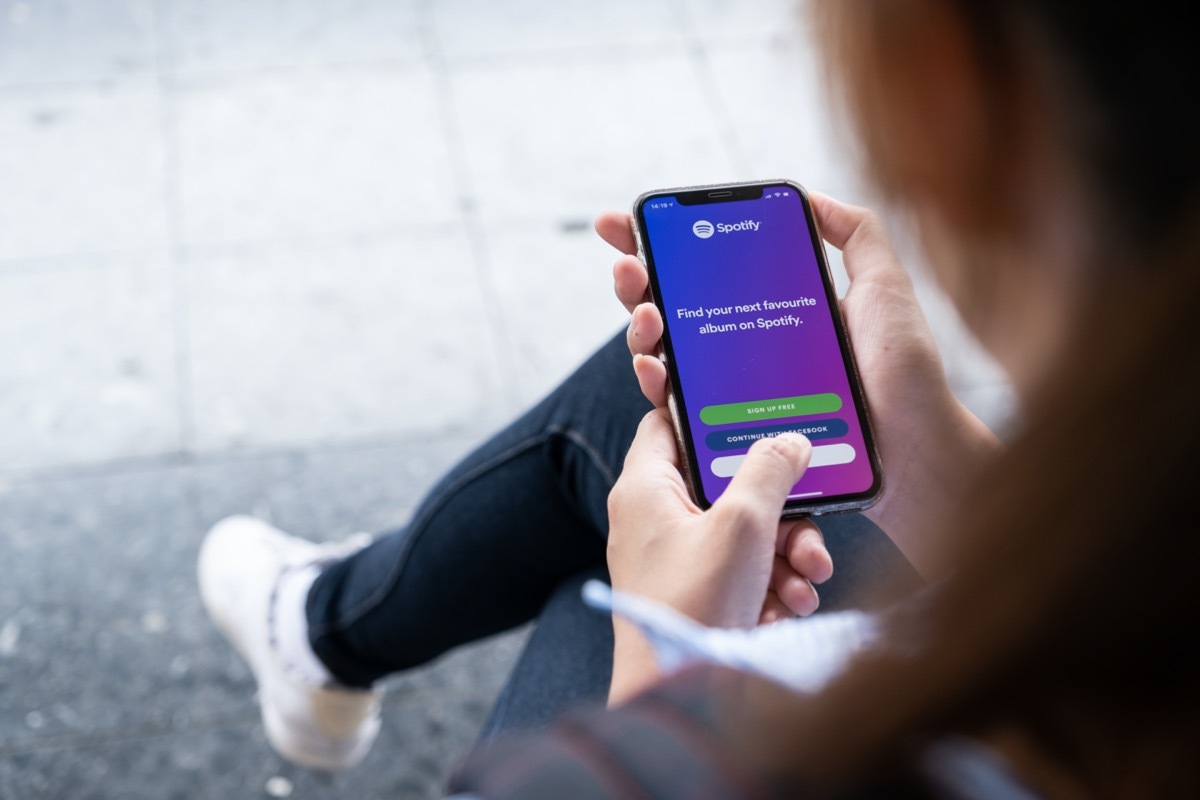 Person holding a brand new Apple iPhone XS with Spotify logo on the screen.