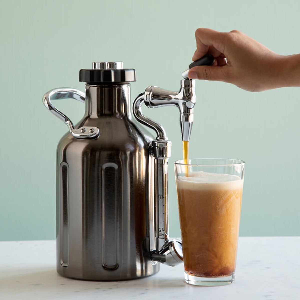 person pouring nitro cold brew into cup