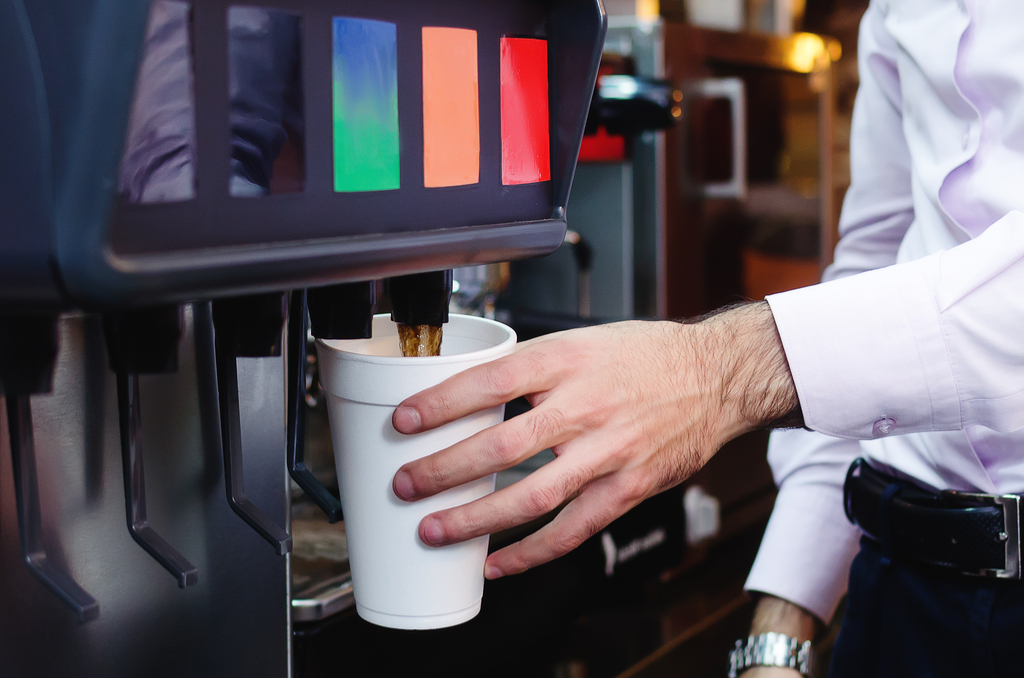 man getting a soda from a machine - american culture