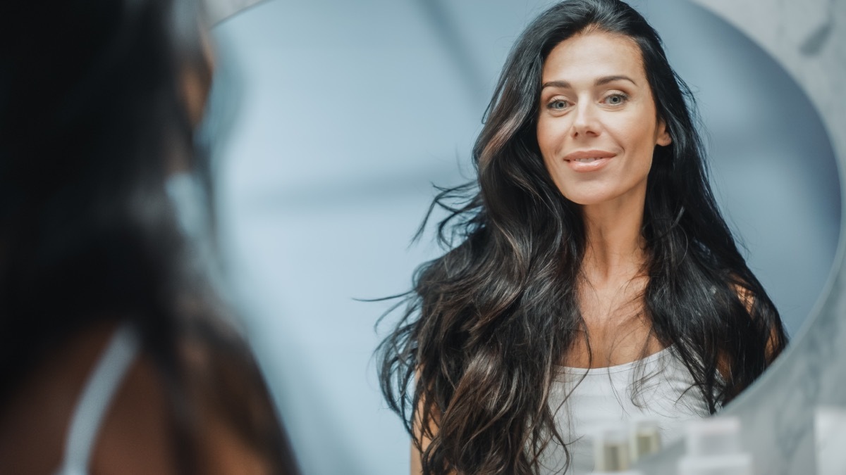 Woman Confidently Looking in Mirror