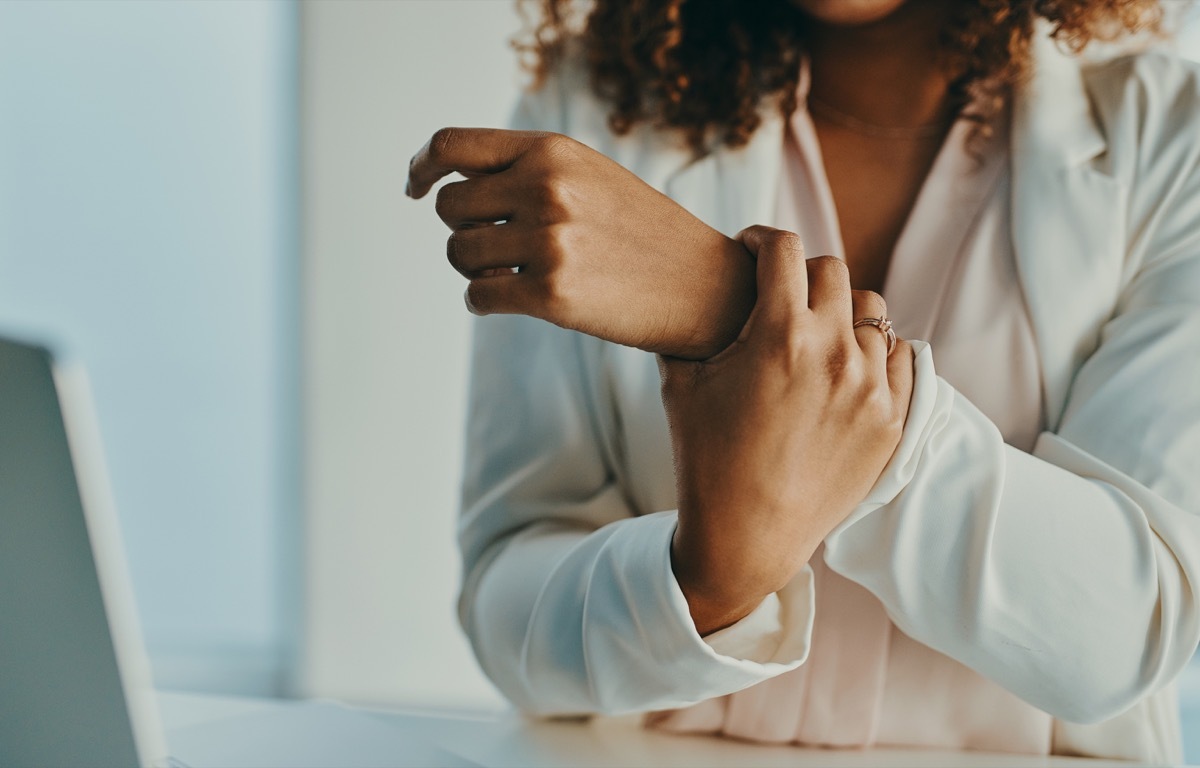 Shot of an unrecognisable businesswoman experiencing wrist pain while working in a modern office