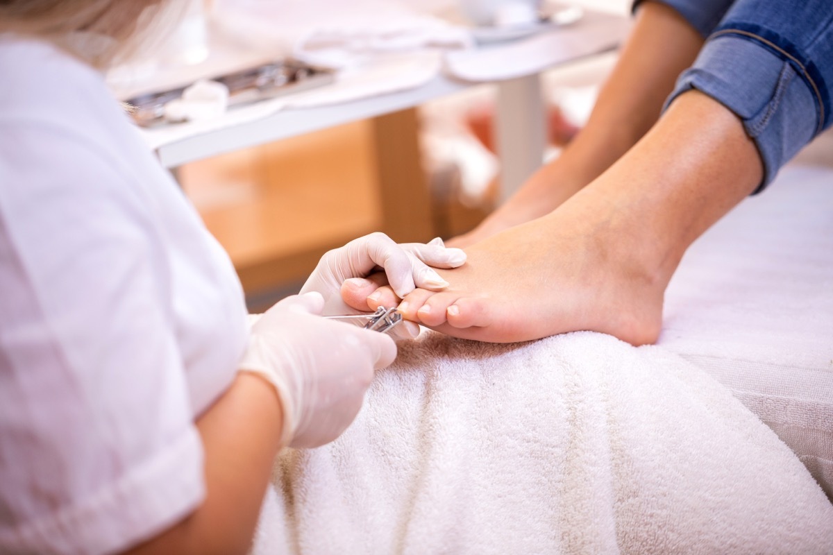 Removing of nail edges with nail clippers in foot spa, pedicure