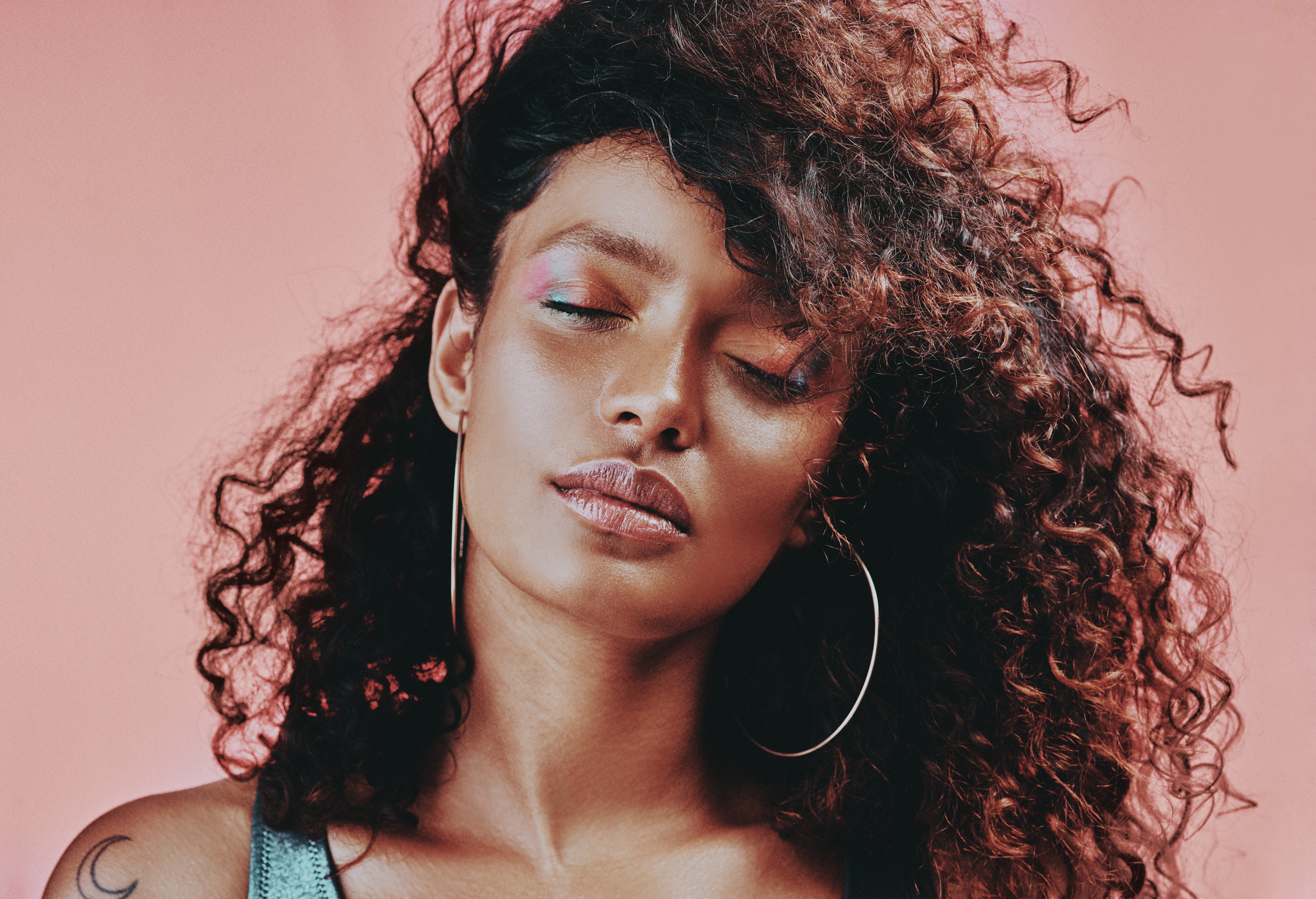 Shot of a beautiful young woman wearing makeup while posing against a pink background