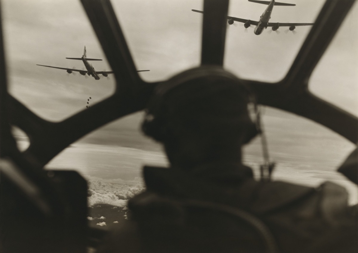 Two B-29 Super-fortresses drop bombs over Malaya as seen from cockpit of third bomber during a run over the important railway yards and repair shops utilized by the Japanese at Kuala Lumpur