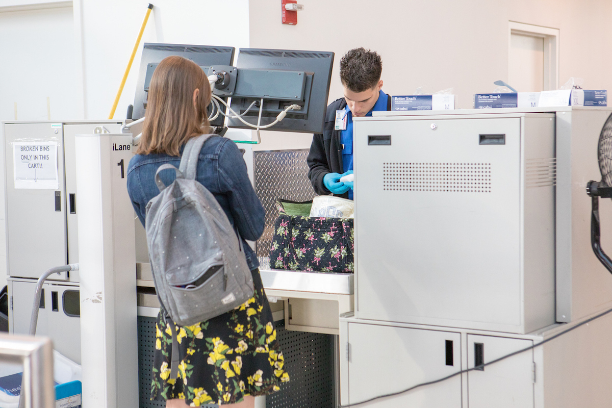 A TSA agent searching a woman's bag at the airport