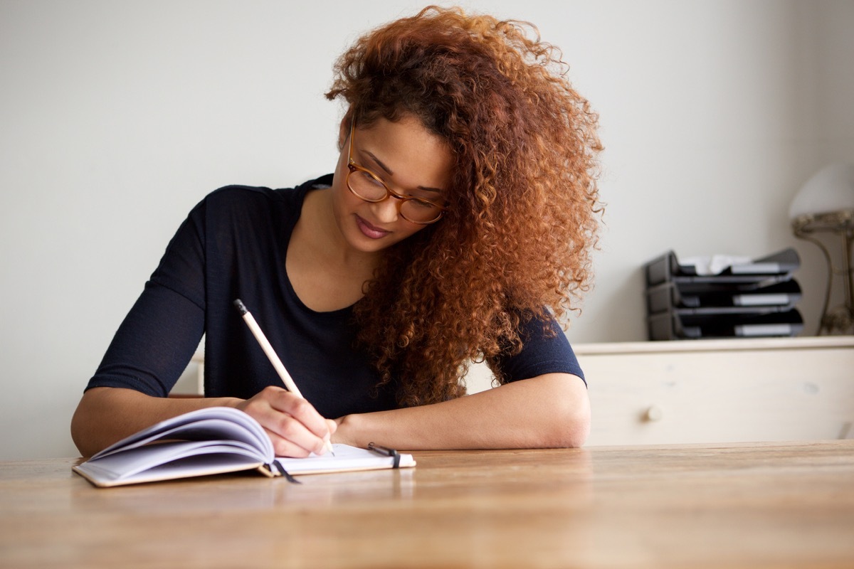 young woman writing in a notebook