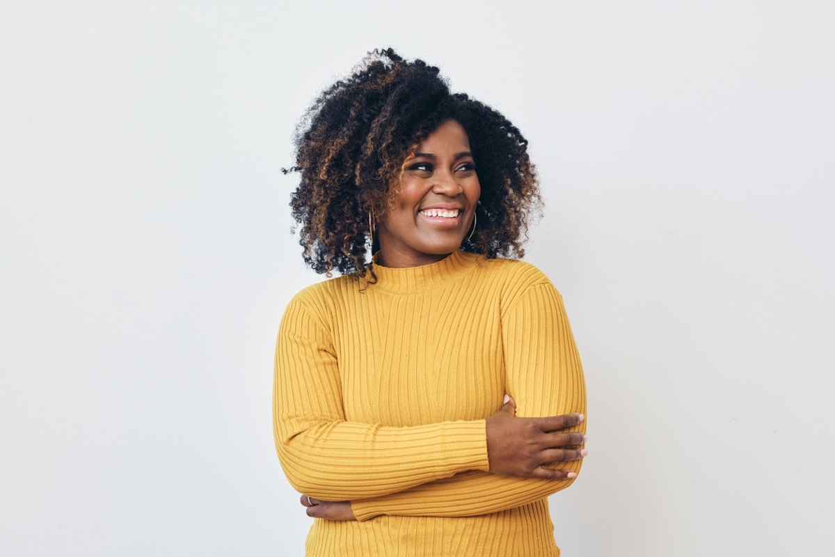 Portrait of smiling beautiful woman standing against white background looking right