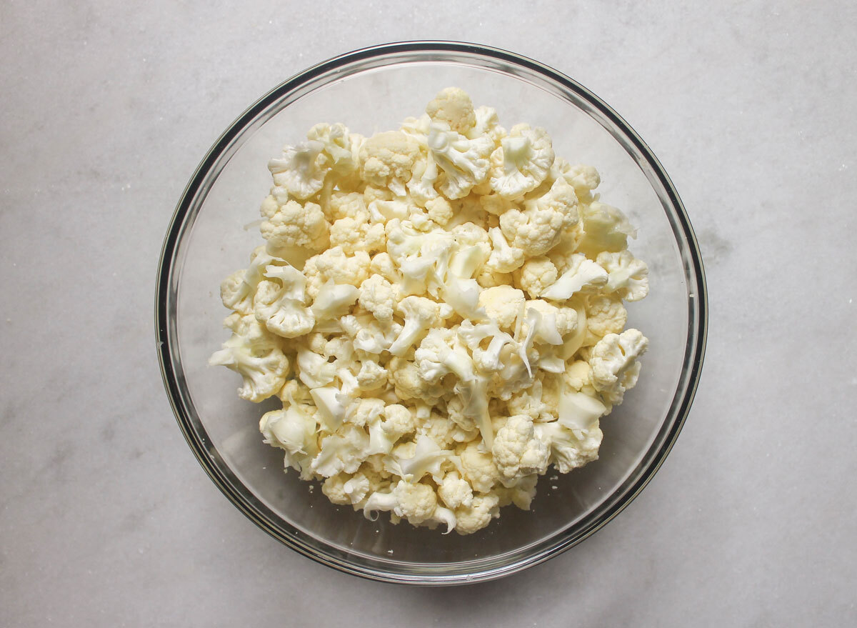 cauliflower florets in a bowl on a marble counter