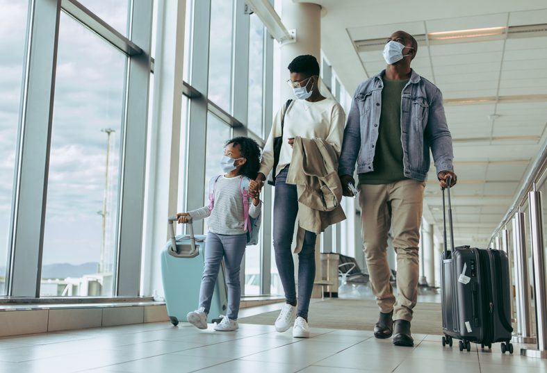 A family boarding a flight with their carry on luggage