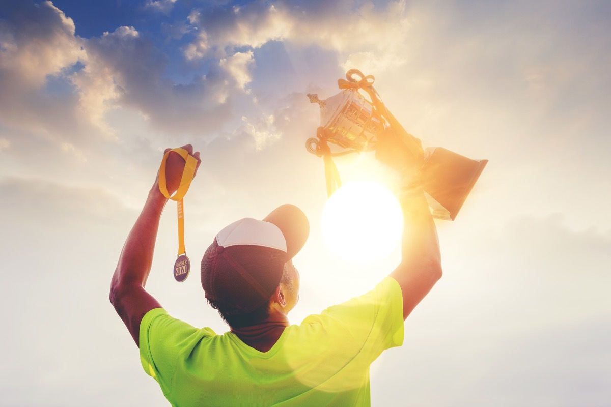 Man holding up trophy and medal