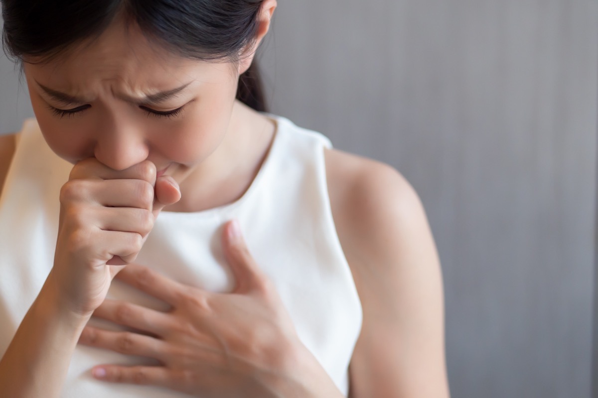 young woman choking with hands on her chest