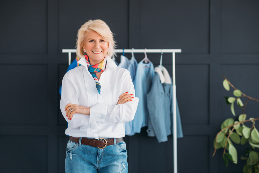 Attractive senior woman wearing white button-down shirt and jeans