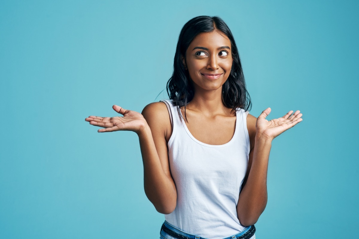 east asian woman smirking and shrugging