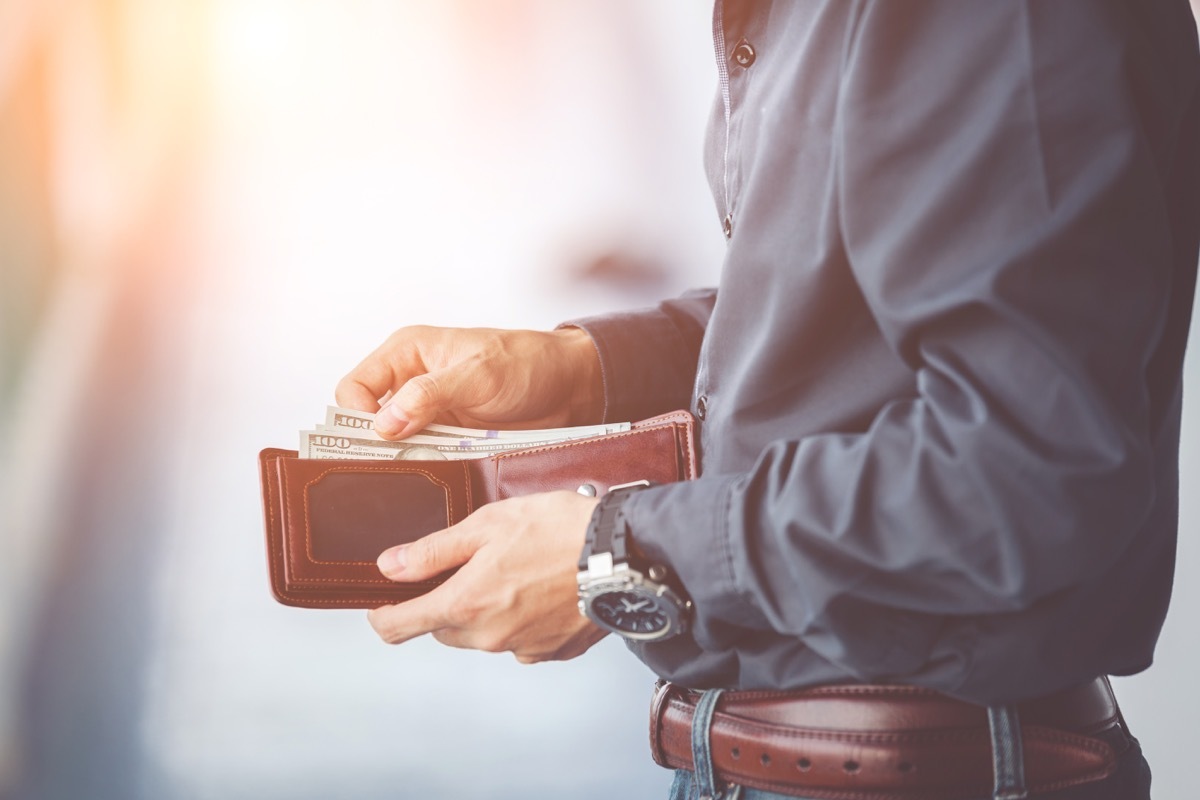 Man opening wallet outside