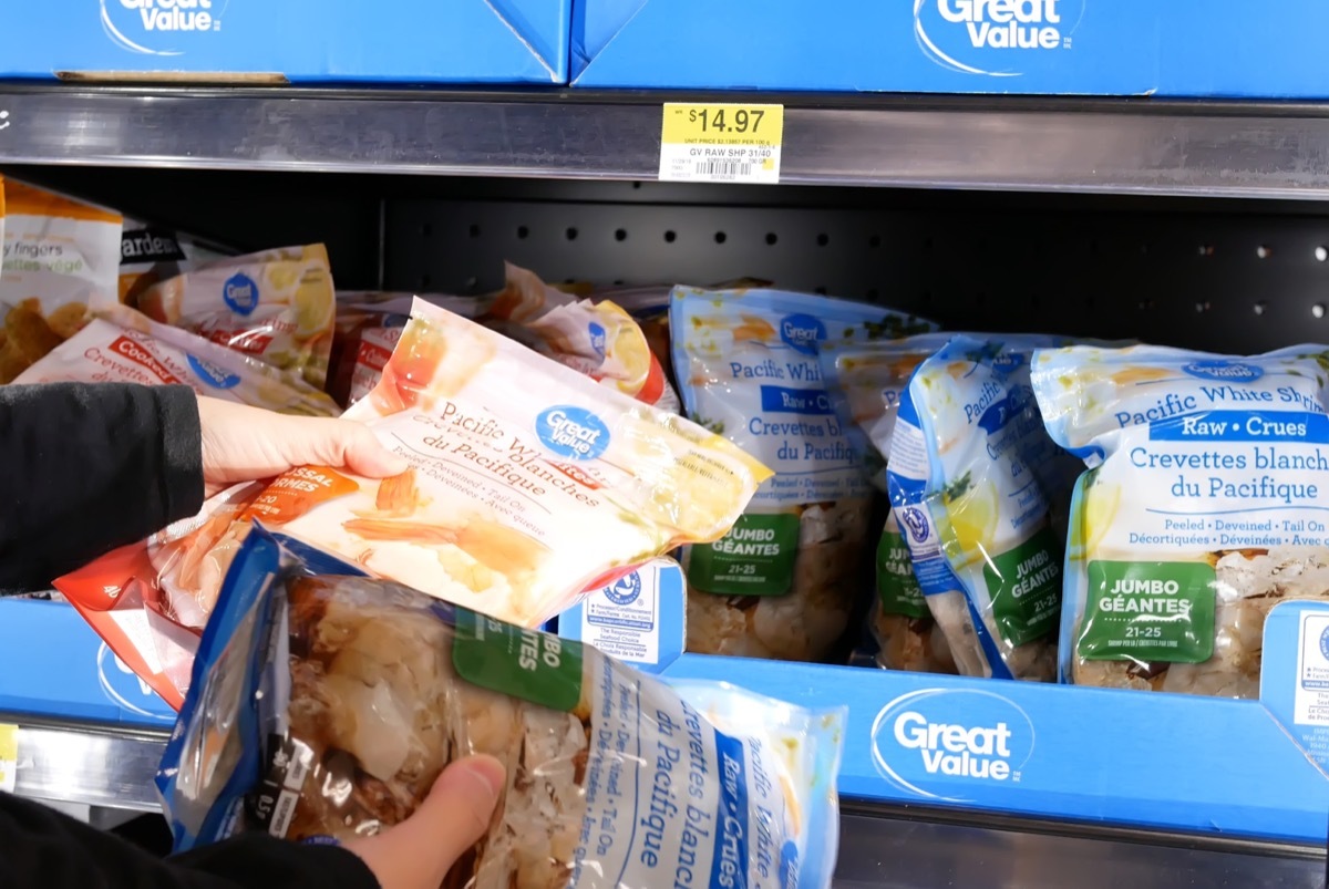 Coquitlam, BC, Canada - April 30, 2019 : Motion of woman buying great value white shrimp inside Walmart store