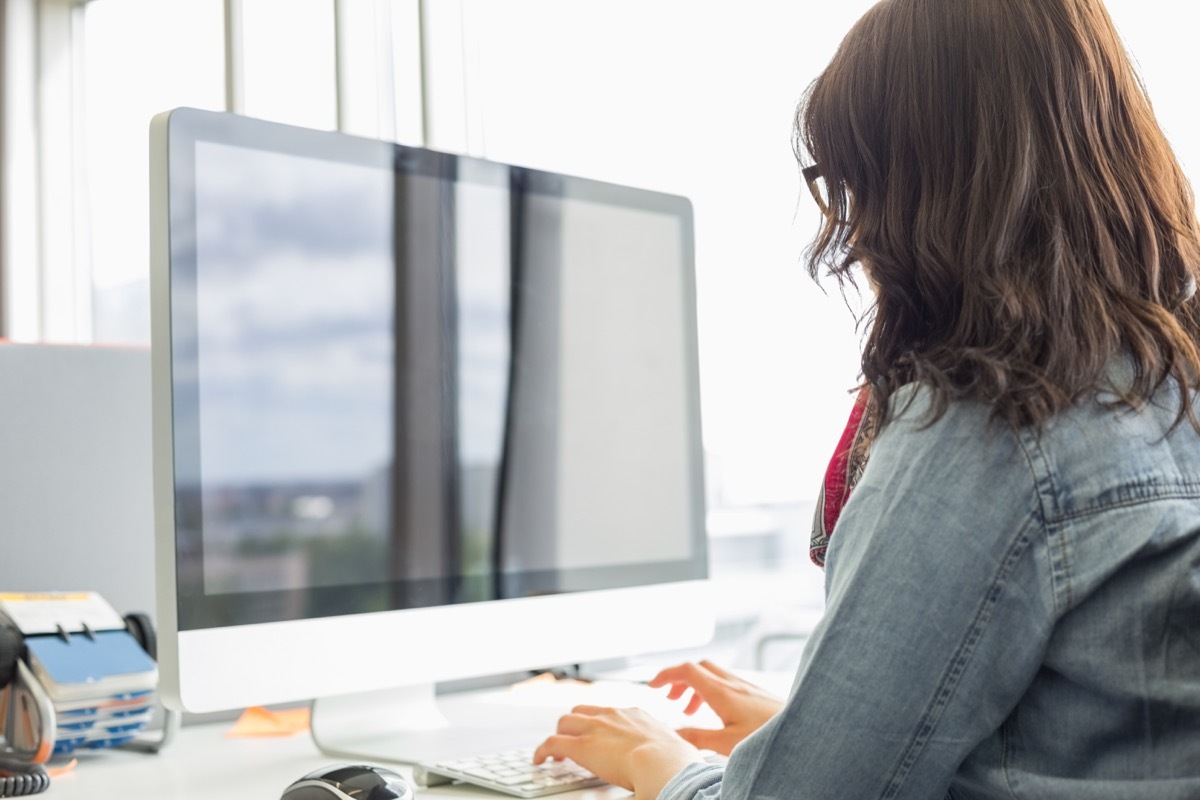 young woman using desktop computer