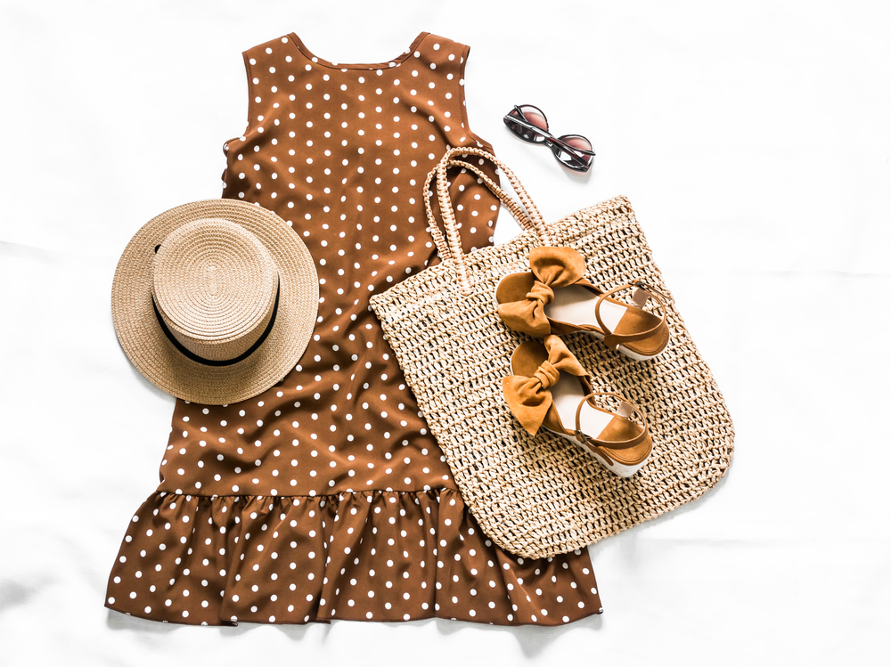 Summer style concept with sleeveless polkadot dress, straw hat, sunglasses, sandals and tote bag