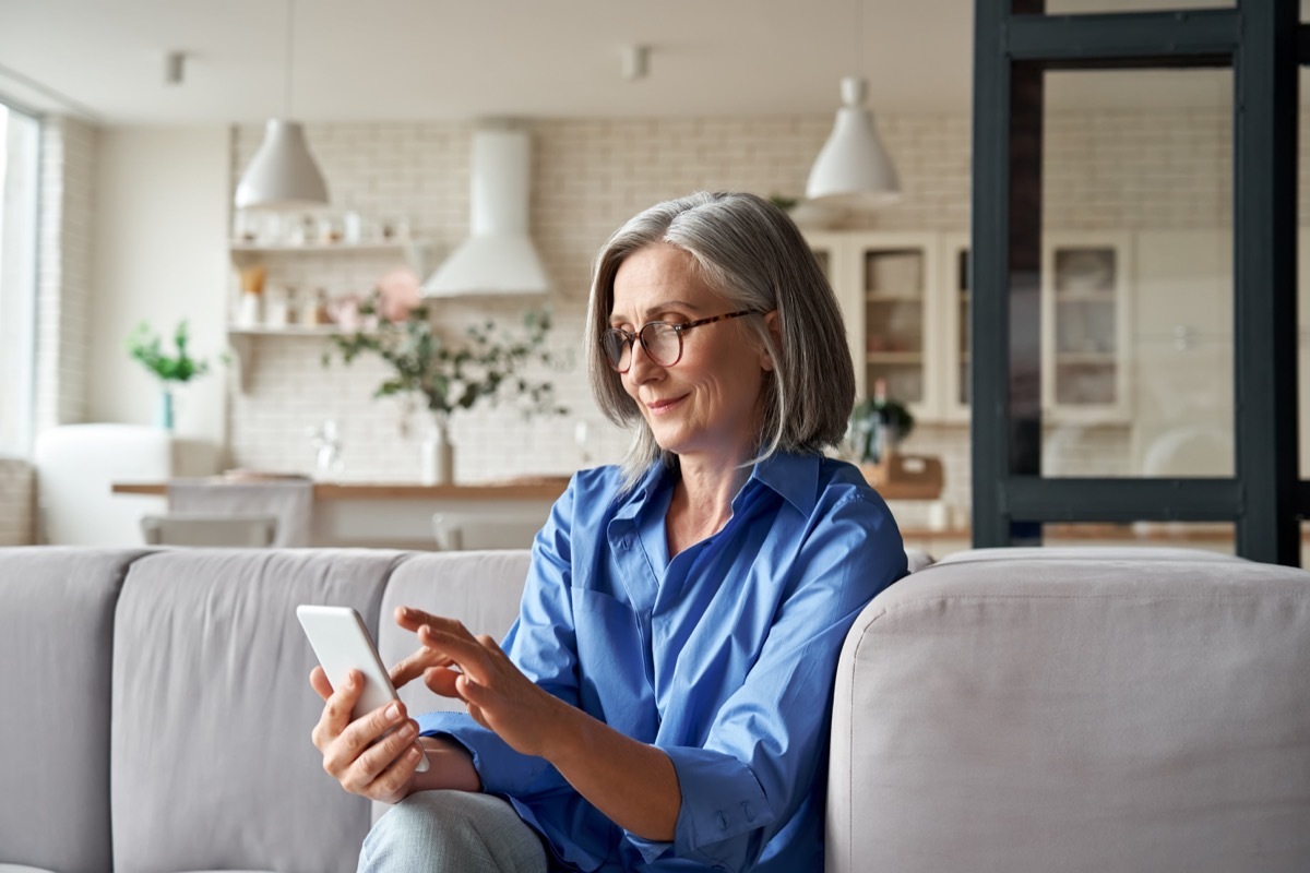 woman smiling as she goes through matches on different senior dating sites