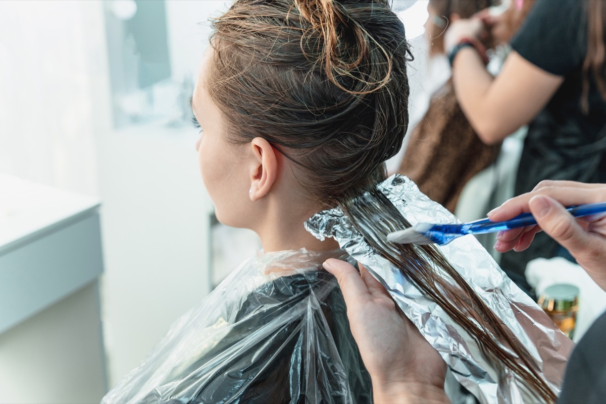 Woman getting her hair dyed with foils