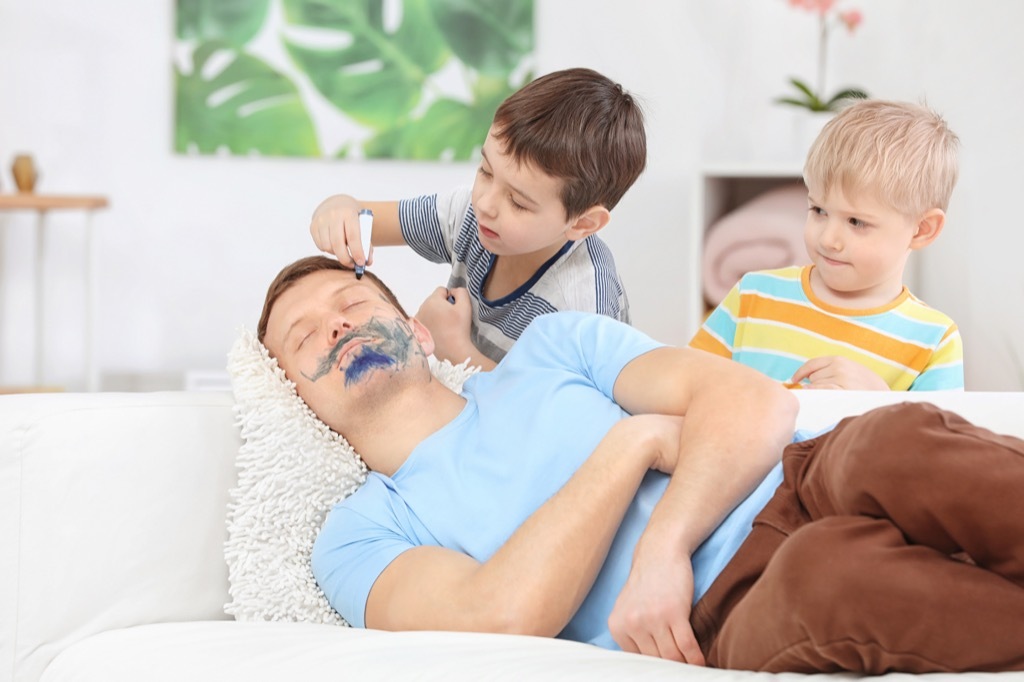 Mischievous children drawing on their father's face