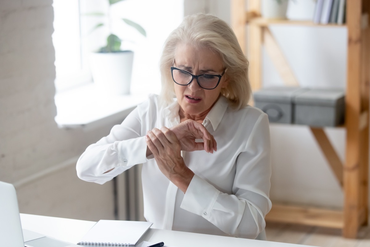 Aged businesswoman sit at workplace desk touch hand feeling wrist pain caused by pc and mouse usage long time wrong arm posture, carpal tunnel syndrome, laptop overwork, joint muscular strain concept