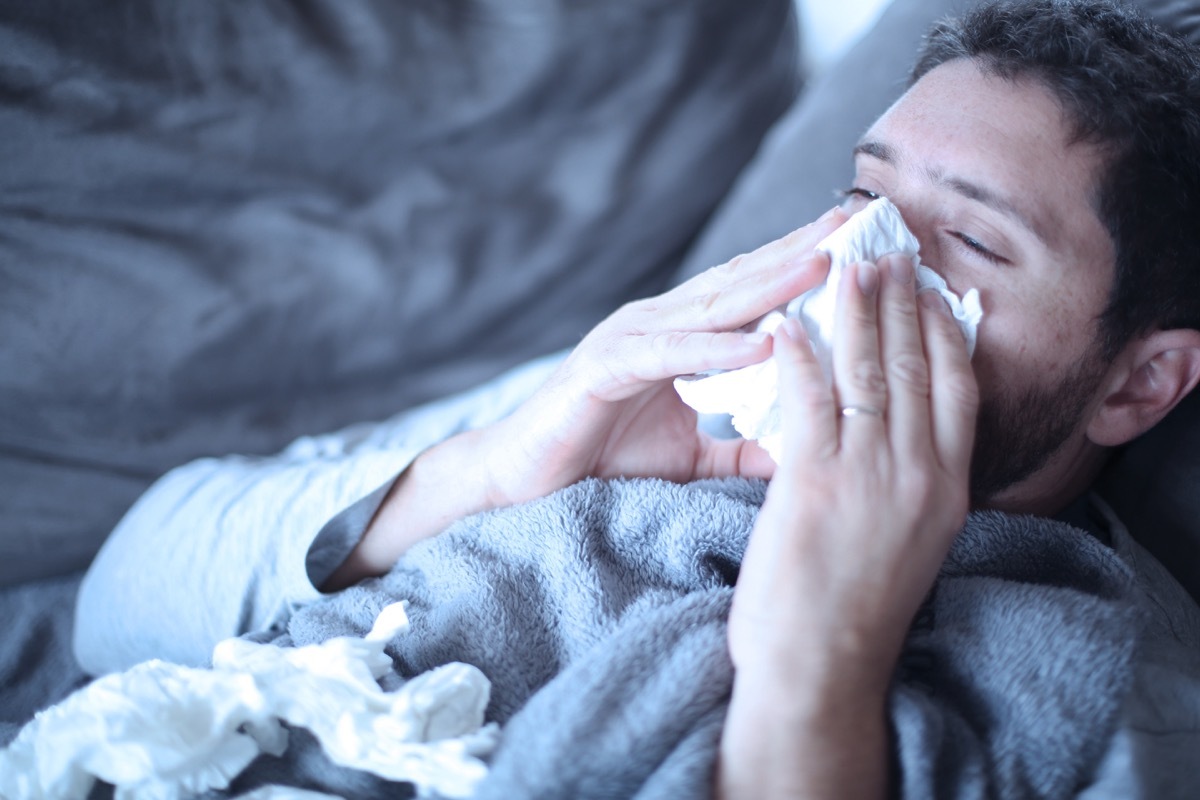 man blowing his nose on the couch body changes over 40