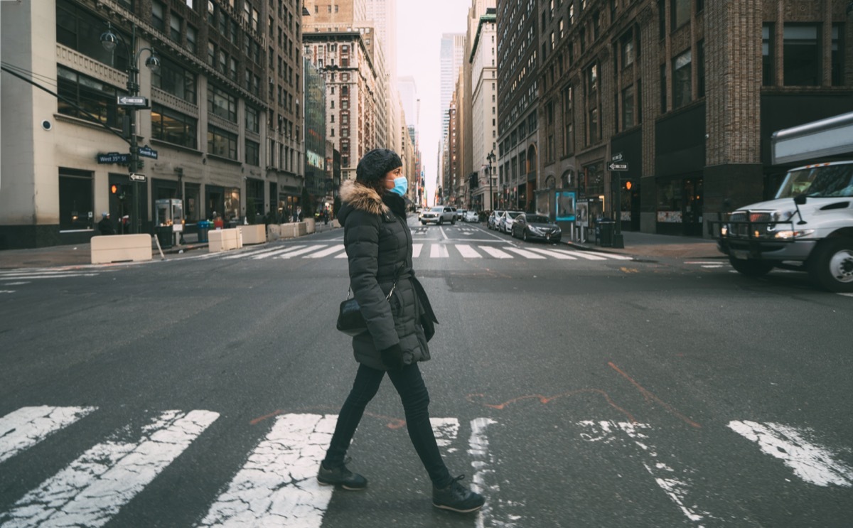 Woman wearing a mask crossing the street in NewYork City