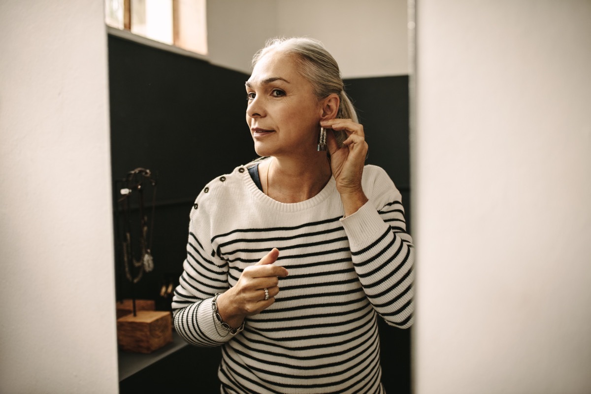 Older Woman with white hair wears earrings, habits that make you age 