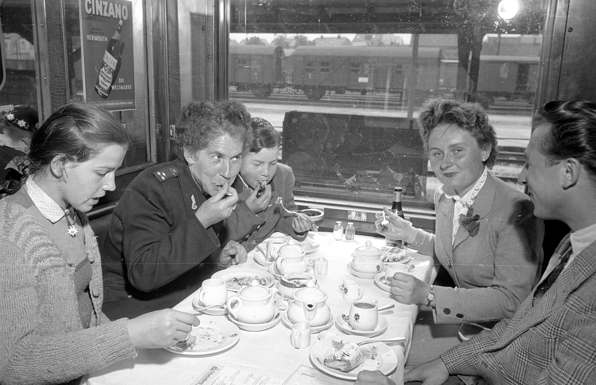 a group of friends eat dinner in a train car