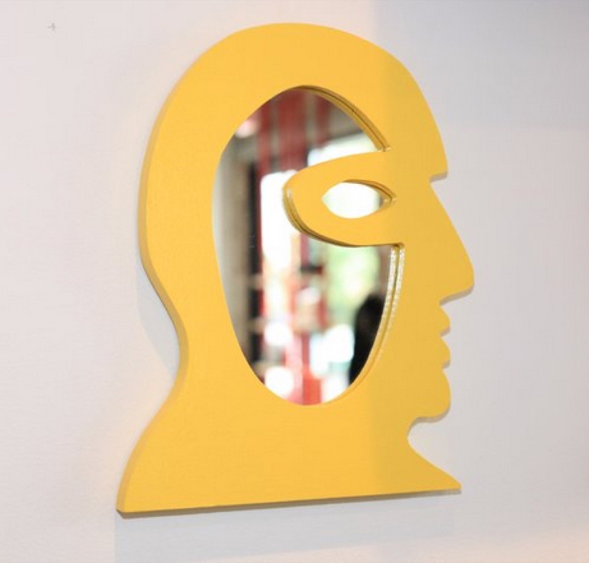 yellow mirror in the shape of a man's face