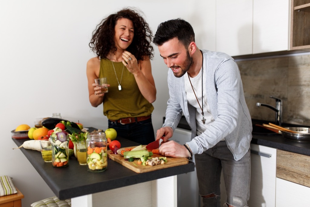 couple chopping vegetables kitchen