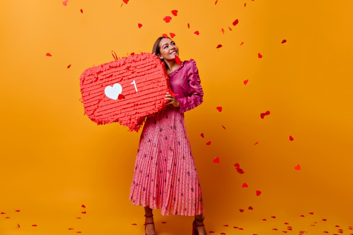 woman holding up a piñata signifying one follower on Instagram