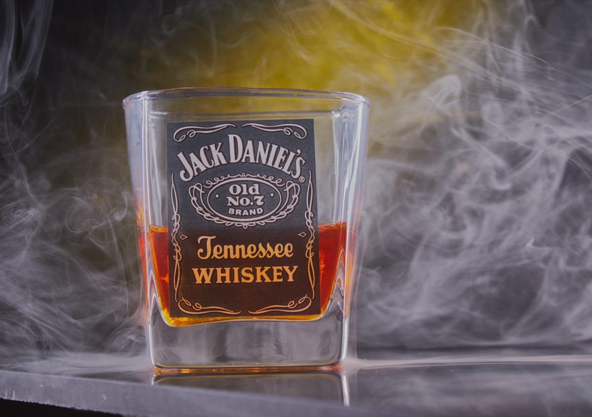 A shot glass of Jack Daniel's in a smoky background