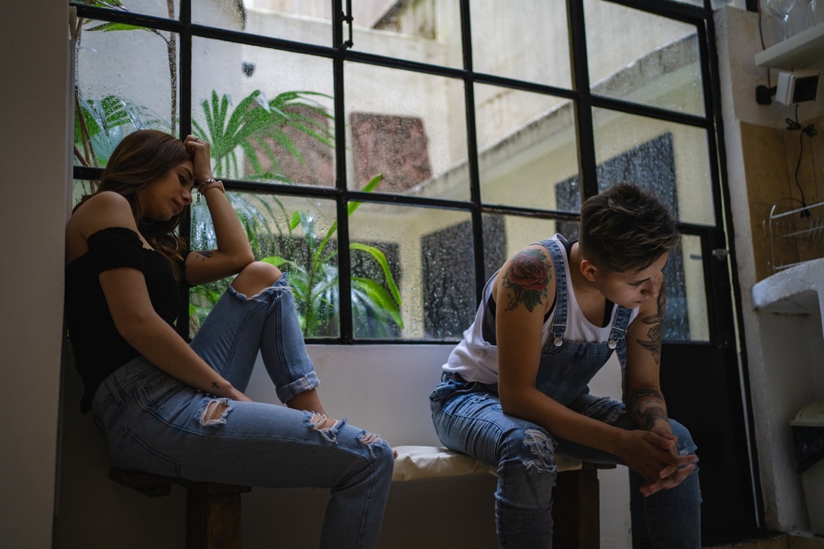 two young lesbians having an argument and sitting apart from each other