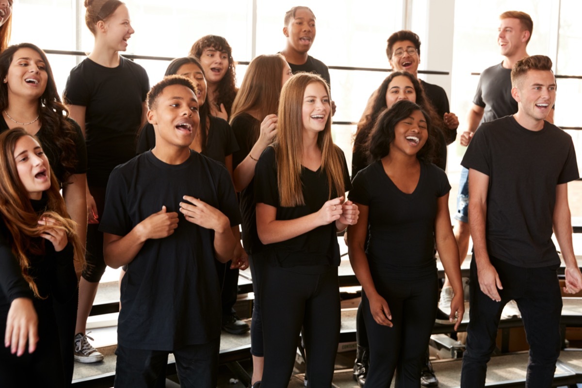 Male And Female Students Singing In Choir At Performing Arts School