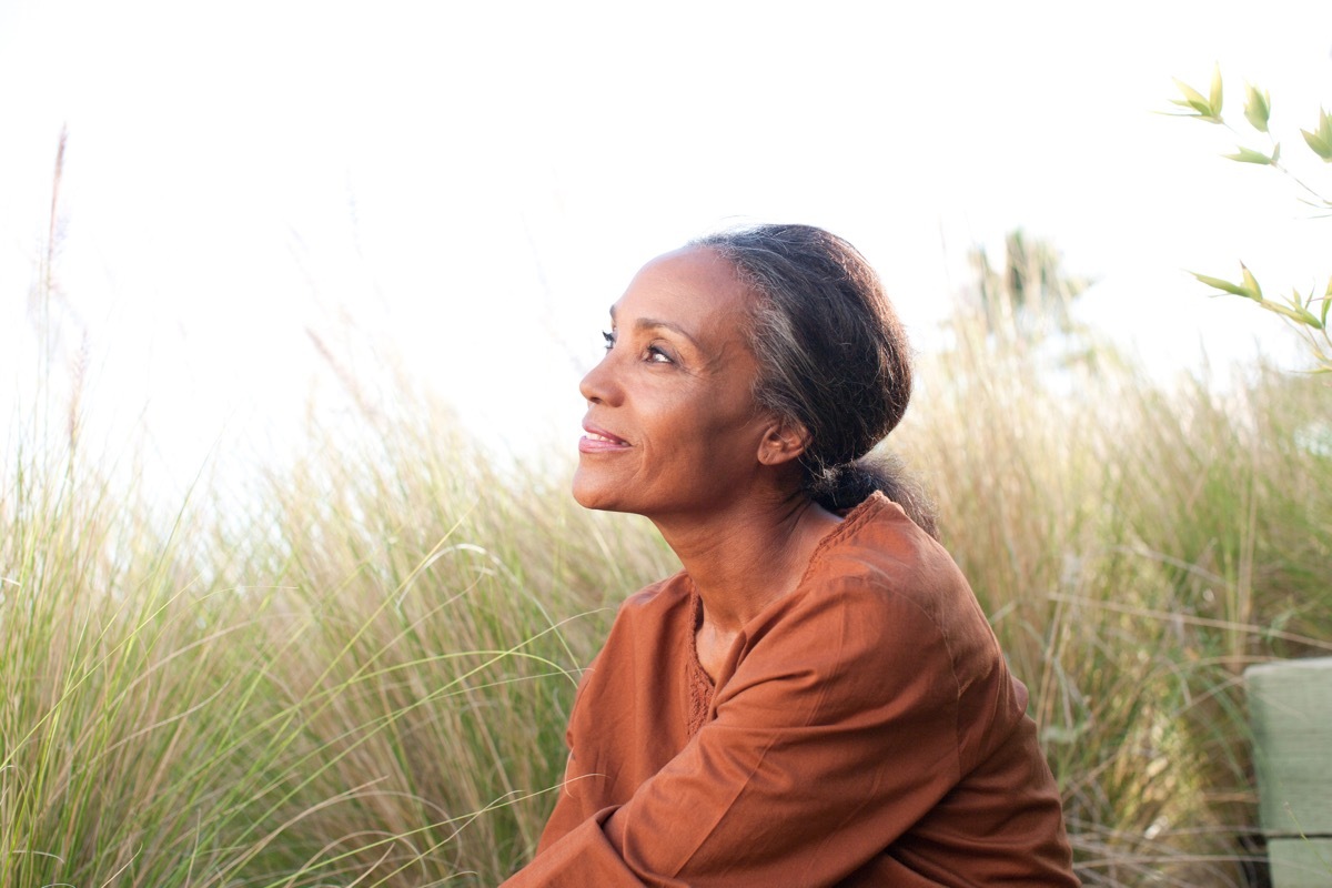 Serene woman sitting in sunny field