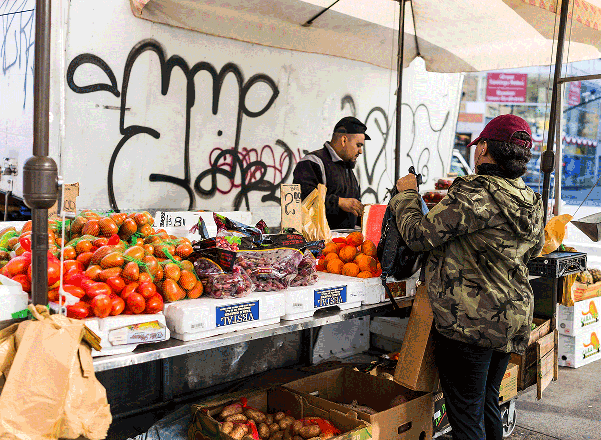 woman buying local produce form man on street