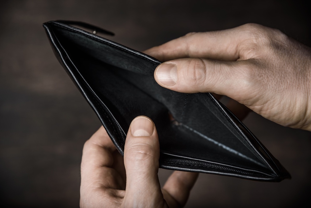 close up of white man's hands opening wallet with nothing inside