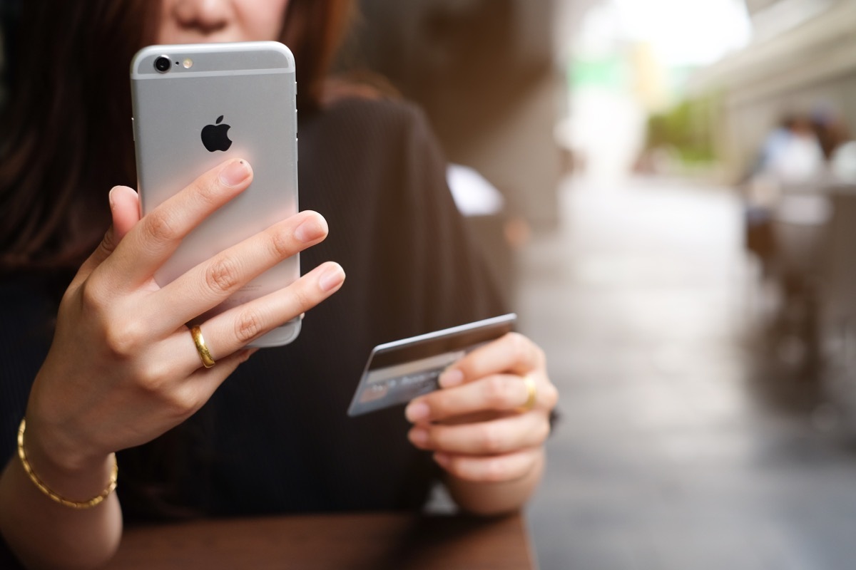 woman buying something on amazon with phone and card