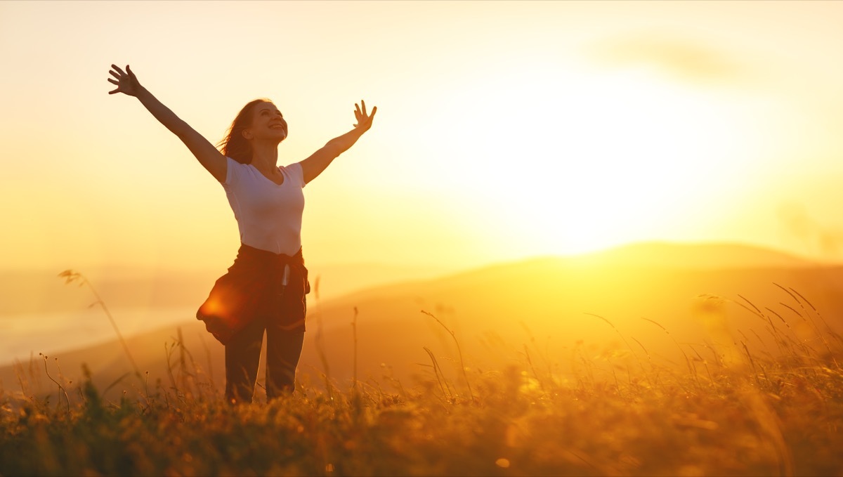 happy woman in nature at sunset