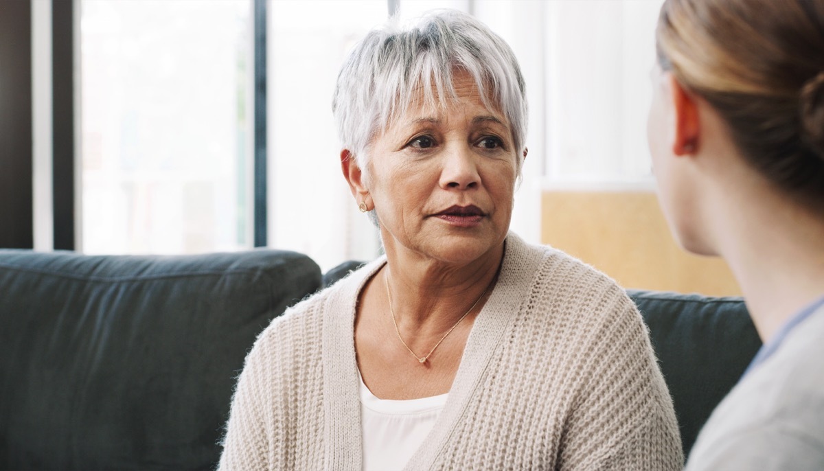 Shot of a nurse consoling a senior woman in a nursing home